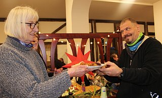 Die ehrenamtliche Mitarbeiterin Ilse Brücke reicht Michael Peemöller eine warme Portion Gulasch mit Kartoffeln und Rotkohl. - Anna-Lena Hinder