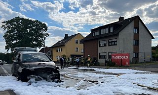 Der Mercedes auf der Jöllenbecker Straße brannte im Frontbereich aus. Auf der Straße ist Löschschaum verteilt. Foto: Paul Brinkmann - Paul Brinkmann