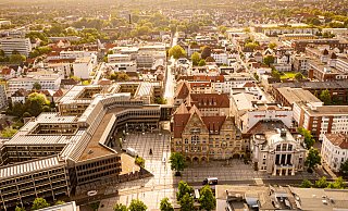 Von Schweizer Finanzinvestoren über regional verwurzelte Autohäuser bis zur Stadt Bielefeld: Geld floss in Bielefeld 2022 von etlichen Beteiligten. - Symbolbild Rathaus/Stadtpanorama: Mike-Dennis Müller