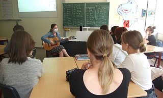 Pädagogin Hedda Schoof gibt Deutschunterricht für ukrainische Flüchtlingskinder am Söerblom-Gymnasium. Sie greift gern zur Gitarre, um so die Sprache intensiver vermitteln zu können. Die Schüler sind mit dem Rücken zur Kamera gekehrt, damit sie aus Sicherheitsgründen nicht zu erkennen sind. - Karsten Schulz