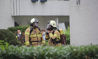 Feuerwehrleute stehen ausgerüstet mit Atemschutzgerät bereit für den Einsatz. - Florian Weyand
