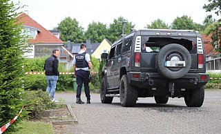Der von Schüssen getroffene Hummer. Zwei Beamte stehen neben dem Wagen. - Charlotte Mahncke