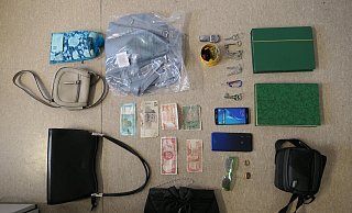 Diese mutmaßlichen Beutestücke konnte die Polizei nicht zuordnen: Zwei grüne Briefmarkenalben, mehrere Handtaschen und Schlüssel, eine Armbanduhr, zwei Handys und Geldscheine in verschiedenen Währungen. - Polizei Paderborn