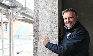 Franz-Axel Kohlschein zeigt am Gebäude in Eissen, dass das Material der Wand zugleich auch die Wärmedämmung ist. - Simone Flörke