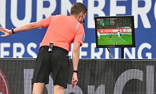 Schiedsrichter Florian Exner schaut sich am TV-Monitor den Zweikampf zwischen Marcel Hoffmeier und Joseph Hungbo an, der zum Foulelfmeter für Nürnberg führt. - Imago Images/Sportfoto Zink