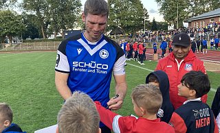 Arminia-Urgestein Fabian Klos gibt einem kleinen Herringhausen-Fan ein Autogramm. - Andreas Gerth