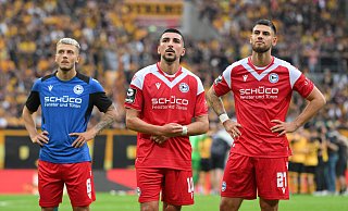 Can Özkan, Nassim Boujellab und Gerrit Gohlke (von links) blicken auf die Tribüne. - IMAGO/Eibner