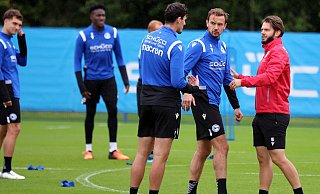 Arminia Bielefeld um Janni Serra und Manuel Prietl (Mitte v.l., im Gespräch mit Athletiktrainer Nikals Klasen) ist am Montag in die Vorbereitung auf das Spiel gegen Hannover 96 gestartet. Beim Mannschaftstraining fehlten einige DSC-Akteure. (Archivfoto) - Oliver Krato
