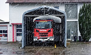 Der große Feuerwehrwagen in Spenge/Hücker-Aschen steht derzeit noch unter einer provisorischen Plane. Bei Wind und Wetter. Und sogar bei Schnee. Wenn das Feuerwehrgerätehaus an anderer Stelle neu gebaut werden sollte, bekommt auch der große Rote eine eigene Garage. - Andreas Sundermeier