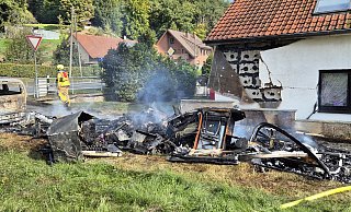 Vom Wohnwagen sind nur verkohlte Reste übrig geblieben. Es braucht viel Fantasie, um herauszufinden, welche Funktion sie einst hatten. - Feuerwehr Bad Oeynhausen