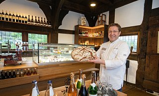 Zwischen der alten kleinen Theke vorn (mit allerlei Süffigem) und der neuen großen, dem historischen Ambiente angepassten hinten hält Gastronom Silvio Eberlein ein rundes Roggen-Weizenbrot in der Hand, das er im speichereigenen Ofen gebacken hat. - Oliver Krato