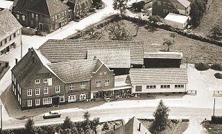 Dieses Luftbild zeigt das Haus Nordbrock und die Parzelle, die heute als das ehemalige Elli-Markt-Grundstück bezeichnet wird, in den 1960er Jahren. Im Vordergrund ist die Fürstenstraße zu sehen. - Heimatverein Verl
