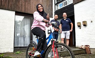 NW Fahrradspende: Mazahir Abdllh (23) aus dem Sudan nimmt das blaue Montainbike stellvertretend für ihre fünf jüngeren Schwestern entgegen. - Michaela Heinze