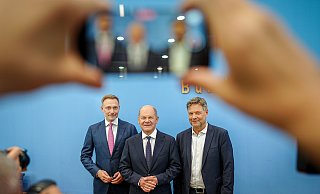 Bundeskanzler Olaf Scholz (SPD, m), Wirtschaftsminister Robert Habeck (Bündnis 90/Die Grünen, r), und Finanzminister Christian Lindner (FDP) nennen Details zum Haushaltsplan 2025. - Kay Nietfeld/dpa