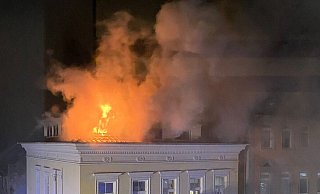 Flammen schlagen aus dem Dach des Wohnhauses. - J. Ahaus