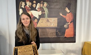 Sonja Voss hält das Spiel Dodelschach in ihren Händen, ein Vorläufer von Tic Tac Toe - Dirk Windmöller