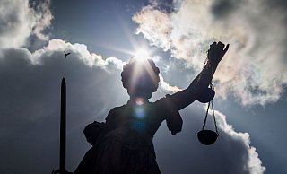 Die Sonne schaut am 26.04.2016 in Frankfurt am Main (Hessen) hinter der Statue der Justitia auf dem Gerechtigkeitsbrunnen auf dem Römerberg hervor. Foto: Frank Rumpenhorst/dpa | Verwendung weltweit - Verwendung weltweit