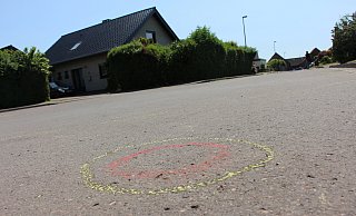 Eine von mehr als 30 Markierungen am Einsatzort in der Salzufler Sackgasse Plaßheide deutet auf die Stellen hin, an denen am Wochenende Patronenhülsen sichergestellt wurden. - Janet König