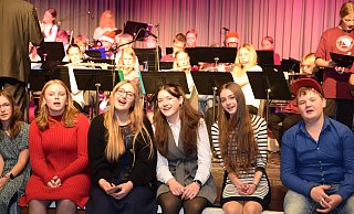 Am Ende kommen alle Akteure auf und vor der Bühne zusammen. Im Hintergrund sind Instrumentalisten der Bläserklasse 5a und der Junior-Big-Band zu sehen, vorne ältere Schülerinnen und Schüler, darunter Solisten Maria Zielke (4. v. r.). - Karin Prignitz