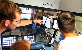 Elektriker Lukas Kohring zeigt Lenn (14) und Tim (15) wofür all die Schalter und Bildschirme im Bahn Cockpit da sind. Foto: Jan Moshage - Jan Moshage