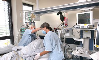 Intensiv-Pflegerinnen betten einen Patienten um. - Frank-Michael Kiel-Steinkamp