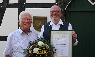 Ernst-Wilhelm Rahe überreicht dem neuen Ehrenvorsitzenden Horst Jording Urkunde und Blumenstrauß. - Klaus Frensing