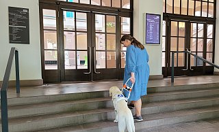 Studentin Adina Kroggel und ihre Assistenzhündin Gusta, der erste Führhund am HAWK-Standort Holzminden, bewältigen eine der vielen Treppen im Gebäude. - HAWK