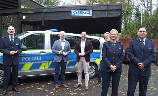 Polizeihauptkommissarin Ilka Hahler und Polizeihauptkommissar Thomas Haese (vorne) vor der Espelkamper Polizeiwache. Im Hintergrund stehen Polizeidirektor Mathias Schmidt (v. l.), Espelkamps Bürgermeister Henning Vieker, Landrat Ali Dogan und Rahdens Bürgermeister Bert Honsel vor dem Einsatzfahrzeug. - Karsten Schulz