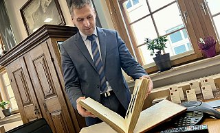 Bürens Bürgermeister Burkhard Schwuchow blättert für die Neue Westfälische im Goldenen Buch seiner Stadt. - Jens Reddeker