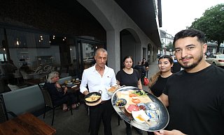 Hasan Çolak (re.) mit Mutter Zekiye sowie seiner Frau Özge und seinem Vater Mehmet vor dem neu eröffneten "LaDö" an der Tribenstraße mit einem "kleinen Frühstück". - Peter Steinert