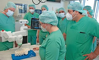 Neurochirurg Carsten Schneekloth, Chefarzt der Klinik für Wirbelsäulenchirurgie (l.), mit einem Teil seines Teams bei der Schulung an dem neuen OP-Roboter. - Brüderkrankenhaus