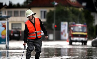 Die Heeper Straße wird zum reißenden Fluss. Ein Feuerwehrmann befreit die Gullys von Blättern und Schlamm, damit das Wasser ablaufen kann. Stundenlang sind die Wehrleute im Einsatz. - Sarah Jonek