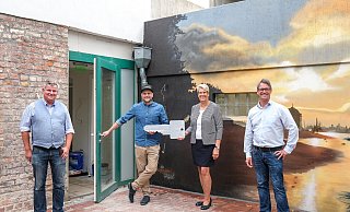Symbolische Schlüsselübergabe: Carsten Becker (Eigentümerfamilie), Koch und Inhaber Marc Lach, Bürgermeisterin Susanne Rutenkröger und Ralf Grund vom Stadtmarketing (v. l.) im Innenhof der „Alten Apotheke Restaurant & Feinkost“. - Stadtmarketing Bünde / Karl-Hendrik Tittel