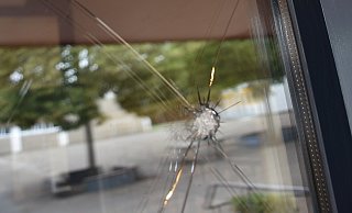 Kreisrunde Löcher in der Eingangstür der Grundschule Neesen: Auf die Glasscheibe ist möglicherweise geschossen worden. - MT-Foto: Dirk Haunhorst