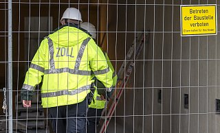 Einsatzkräfte des Zolls betreten eine Baustelle. - picture alliance/dpa