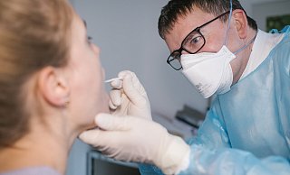 Ein Mediziner nimmt bei einer Patientin einen Abstrich für einen Corona-Schnelltest. - Picture Alliance