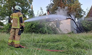 Die Feuerwehrkräfte löschen den Brand von außen. Der Giebel ist bereits eingestürzt. - Peter Heidbrink