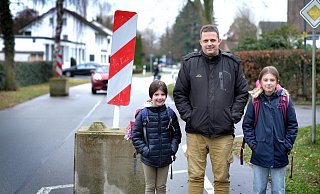Anwohner Guntmar Wolff, hier mit seinen beiden Töchtern Olivia (l.) und Ashley, setzt sich dafür ein, dass die Verkehrsberuhigung mit den Betonklötzen auf der Niehorster Straße beibehalten wird. - Andreas Frücht