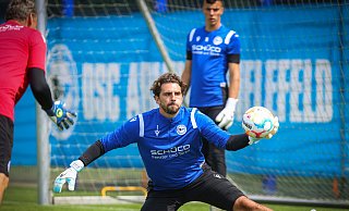 Volle Konzentration auf den Ball: Torhüter Stefanos Kapino (Mitte) beim Training von Arminia Bielefeld mit Torwarttrainer Marco Kostmann (l.). Nach seiner Verletzung muss sich der Grieche in der Torhüterordnung des DSC zunächst hinter Arne Schulz (r.) und Stammkeeper Martin Fraisl einsortieren. - Sarah Jonek