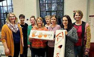 Bibliotheks-Chefin Petra Beck, Stefanie Möller, Präsidentin der Soroptimistinnen Bad Oeynhausen/Wittekindsland, Carolina Erk, Agnes Barth (Frauenhaus), Projektleiterin Gabriele Kasper, Katja Heidemann, Daniela Albrink und Nadine Heine (Frauenhaus) zeigen Steine, die Bewohnerinnen des Frauenhauses künstlerisch gestaltet haben. - Frank-Michael Kiel-Steinkamp