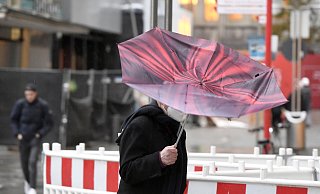 Der Regenschirm eines Passanten wird vom Sturm erfasst. Der Wetterdienst hat für heute im südlichen Nordrhein-Westfalen eine Unwetterwarnung mit orkanähnlichen Böen und Starkregen vorhergesagt. - Roberto Pfeil/picture alliance/dpa