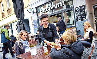 Imbiss-Chefin Aria Berkin serviert einem Gast die Extrawurst. - Barbara Franke