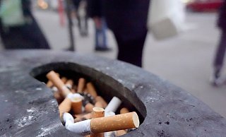 Zigarettenkippen liegen draußen in einem Aschenbecher. Innen darf nicht mehr geraucht werden. - dpa