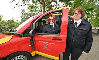 Die Kinderfeuerwehrwartinnen Verne Loges und KarinaSchönfelder freuen sich über das Mannschaftstransportfahrzeug. - f