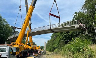 Am 25. Juni wurde die 110 Tonnen schwere Brücke von zwei Kränen neben der Fahrbahn der B1 abgelegt - Ralph Meyer Am 25. Juni wurde die 110 Tonnen schwere Brücke von zwei Kränen neben der Fahrbahn der B1 abgelegt - Ralph Meyer