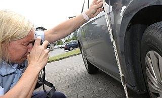 Eine Mitarbeiterin der Polizei ermittelt nach einem Fall von Fahrerflucht. - Patrick Menzel