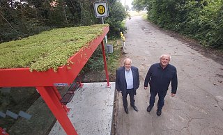 Bürgermeister Rüdiger Meier (links) und Bauhofleiter Klaus Westerholz stellen die neue Bushaltestelle vor. Das Dach ist begrünt. - Florian Weyand