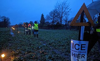 In Elverdissen: Auf einem Rapsfeld zeigen Gegner der Neubaustrecke den Verlauf der Trasse. - Susanne Blersch