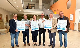 Jörg Isermann (Kreis Höxter, v.l.), Tobias Brüggemann (Facharzt für Hygiene und Umweltmedizin), Barbara Blömer (Kreis Höxter), Michael Rüsenberg (Hygienefachkraft), KHWE-Geschäftsführer Christian Jostes und Jochen Balke (Hygienefachkraft) mit den Hygienesiegeln. - KHWE