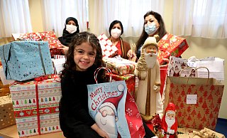 Die dreijährige Karina ist voller Vorfreude, während Aicha Mohammed, Karinas Oma Samiera Shuko und Salwa Al-Mahmod über die Vielzahl der Päckchen bei der Caritas staunen. - Frank-Michael Kiel-Steinkamp